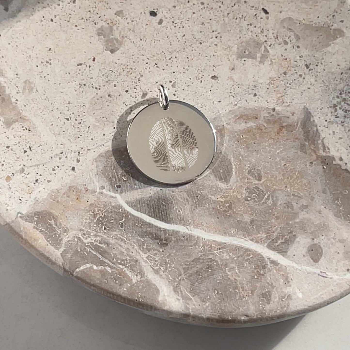 A 925 Sterling Silver Actual Three Fingerprint Personalized Custom Memorial Engraved Pendant in a small bowl