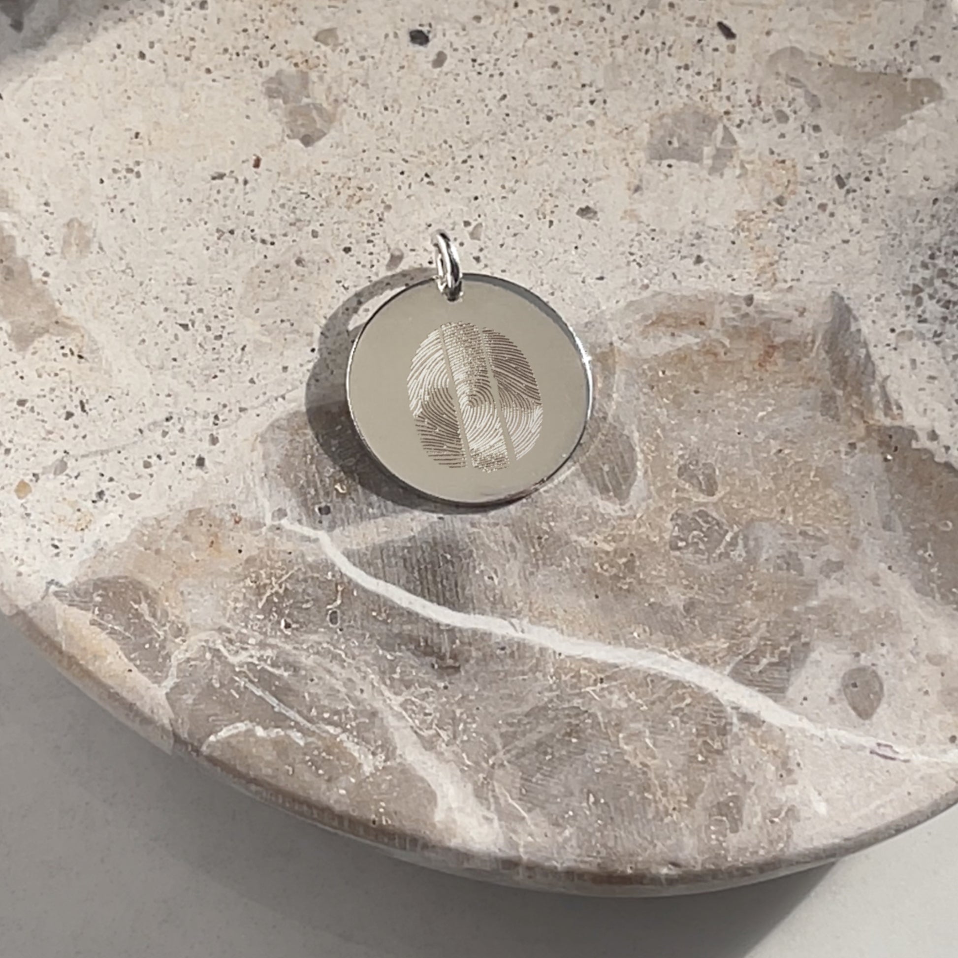 A 925 Sterling Silver Actual Three Fingerprint Personalized Custom Memorial Engraved Pendant in a small bowl