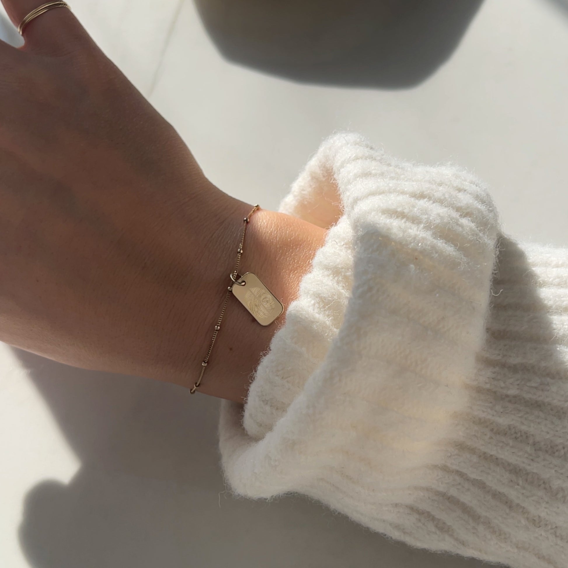 Woman wearing a 10K solid gold Actual Two Fingerprint Custom Engraved Rectangle Bracelet