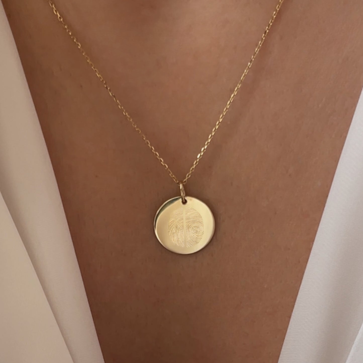 Woman wearing a solid gold pendant with 2 fingerprints