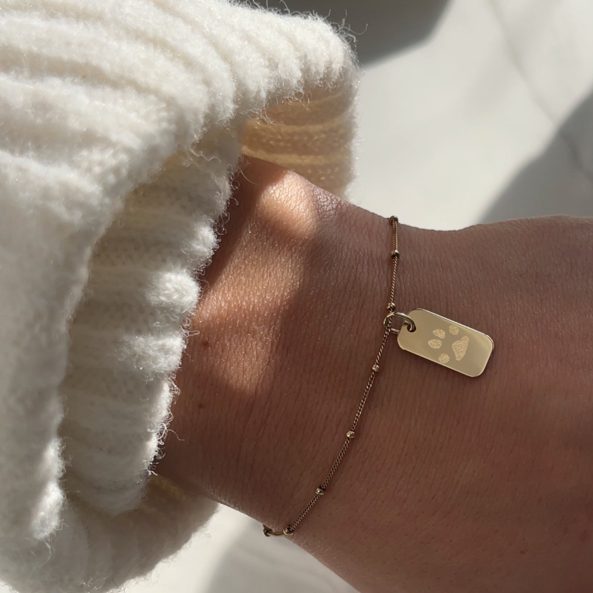 woman wearing a 10K solid gold Actual Dog’s Paw print Personalized Custom Memorial Engraved rectangle Bracelet