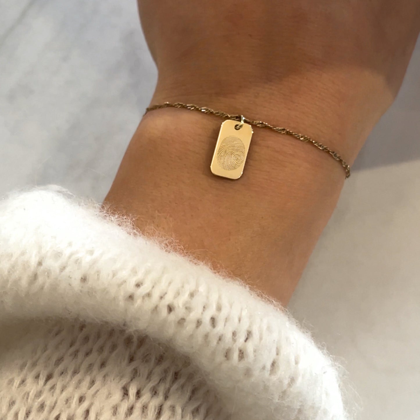 woman wearing a 10K solid gold Actual Fingerprint Memorial Engraved Rectangle Twisted Bracelet