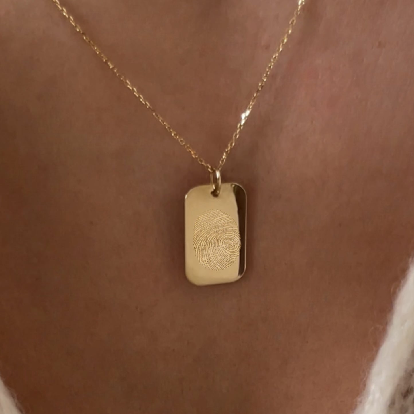 woman wearing rectangle solid gold fingerprint pendant