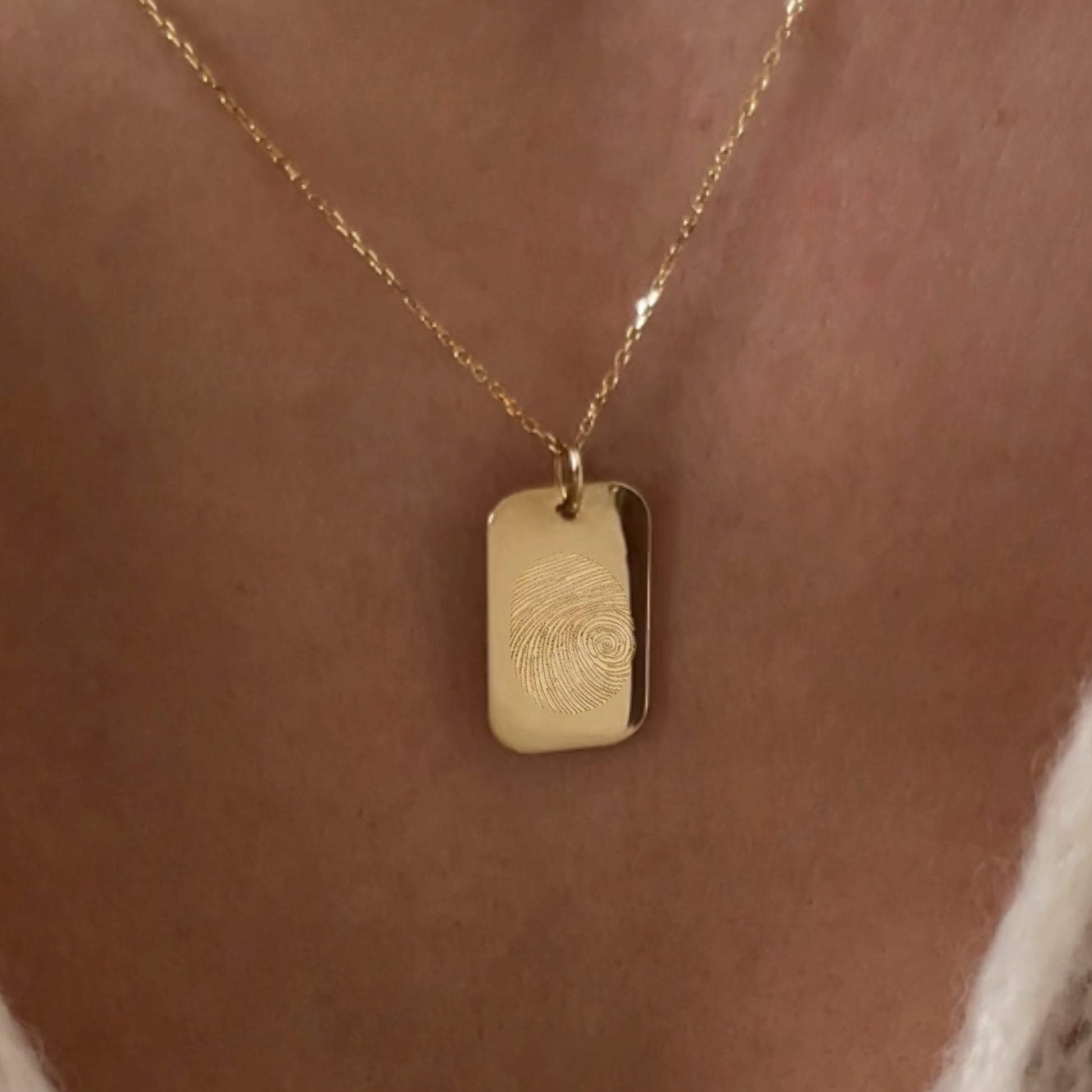 woman wearing rectangle solid gold fingerprint pendant