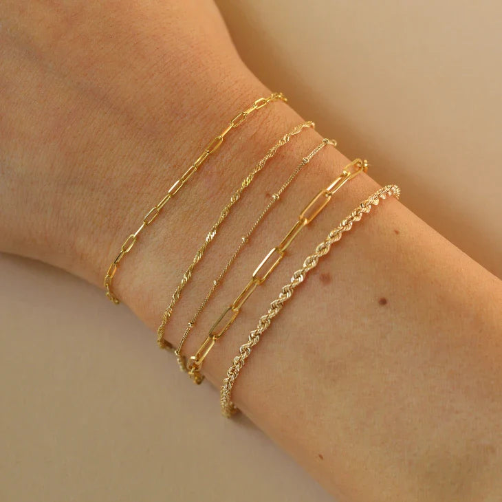 10k solid gold bracelets stacked on a women's wrist