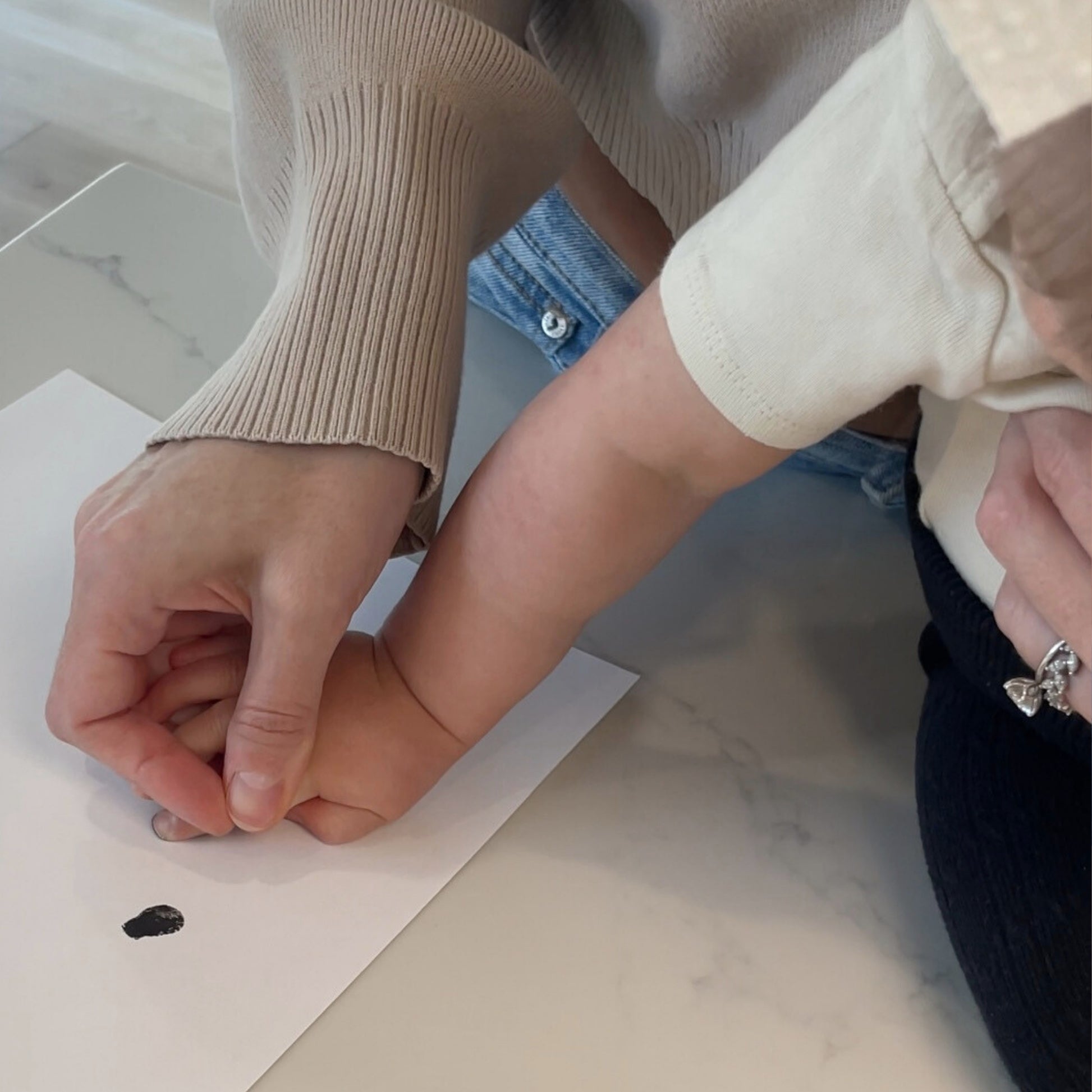 Mom taking baby's tiny fingerprint to engrave on a pendant 