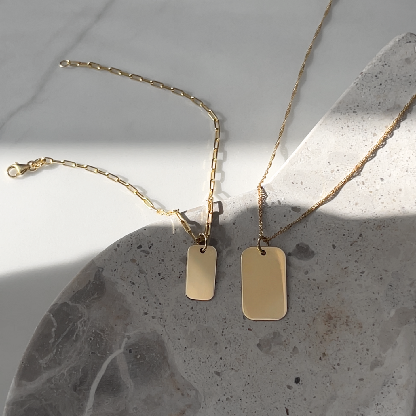 Solid gold Paperclip chain Bracelet next to gold twisted chain necklace ready to be engraved 