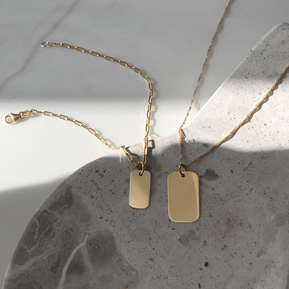 Solid gold Paperclip chain Bracelet next to gold twisted chain necklace ready to be engraved 