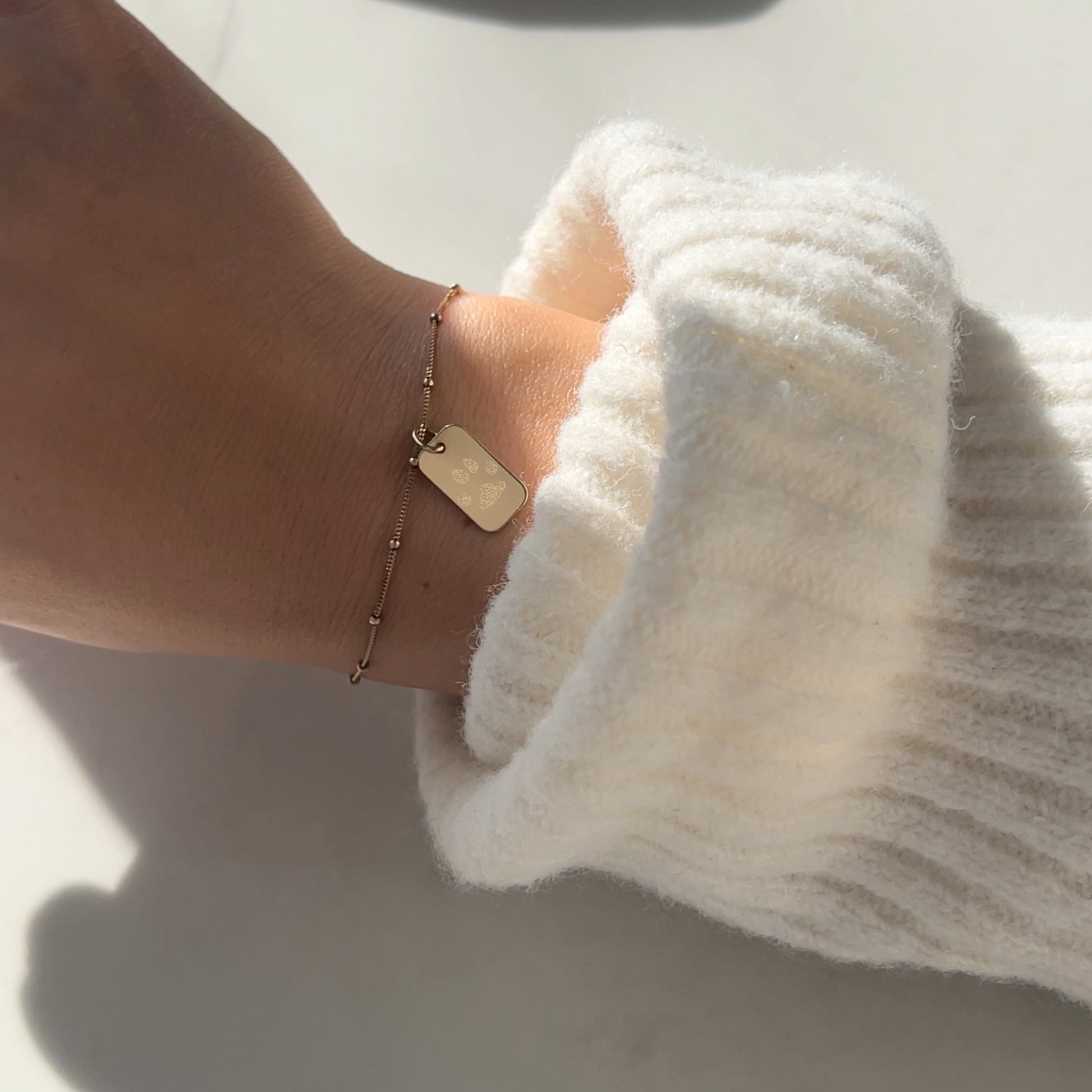 woman wearing a 10K solid gold Actual Dog’s Paw print Custom Memorial Engraved rectangle Bracelet
