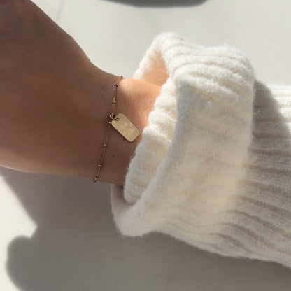 woman wearing a 10K solid gold Actual Dog’s Paw print Custom Memorial Engraved rectangle Bracelet
